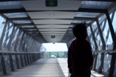 Rear view of woman standing in corridor