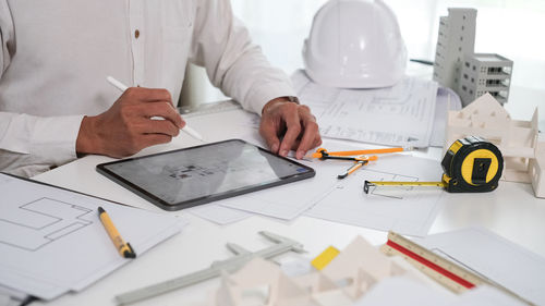 Midsection of businessman working on table