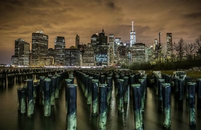 View of illuminated city against cloudy sky