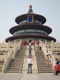 People on steps of temple against clear sky