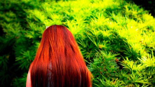 Rear view of woman with red leaves