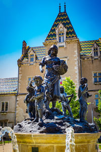 Statue against temple building against sky