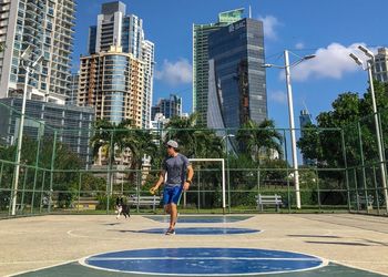 Full length of man and buildings against sky in city