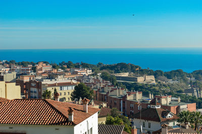 High angle view of townscape by sea against sky