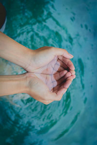 High angle view of human hand holding swimming pool