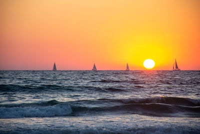 Scenic view of sea against orange sky