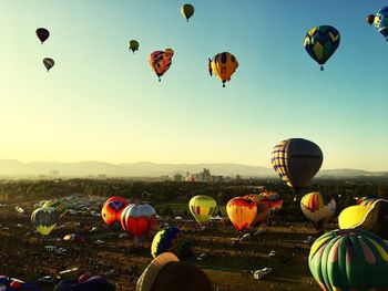Hot air balloons flying over landscape against sky