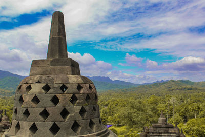 Stupas of building against cloudy sky