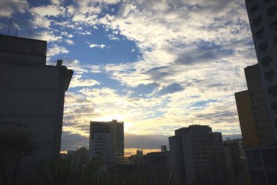 Low angle view of buildings against cloudy sky