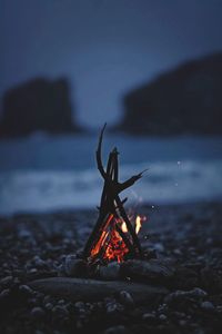 Close-up of bonfire on rock at beach