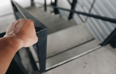 High angle view of person holding metal railing