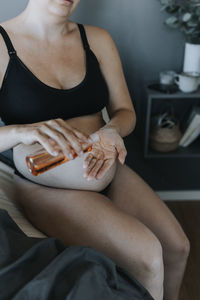 Pregnant woman doing body care routine