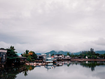 Scenic view of lake by buildings against sky