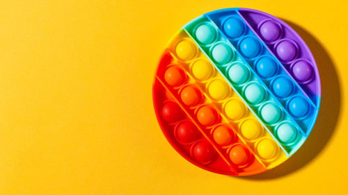 Directly above shot of multi colored candies against yellow background