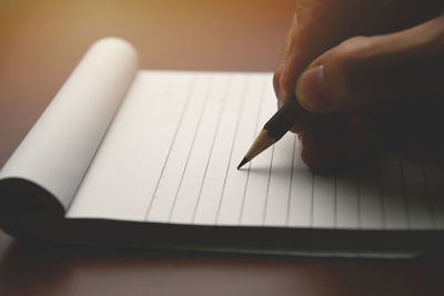 Midsection of person reading book on paper