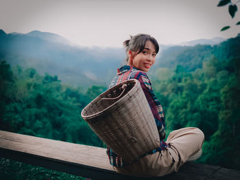 Portrait of smiling young woman standing on mountain