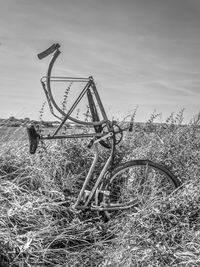 Abandoned metal structure on field against sky