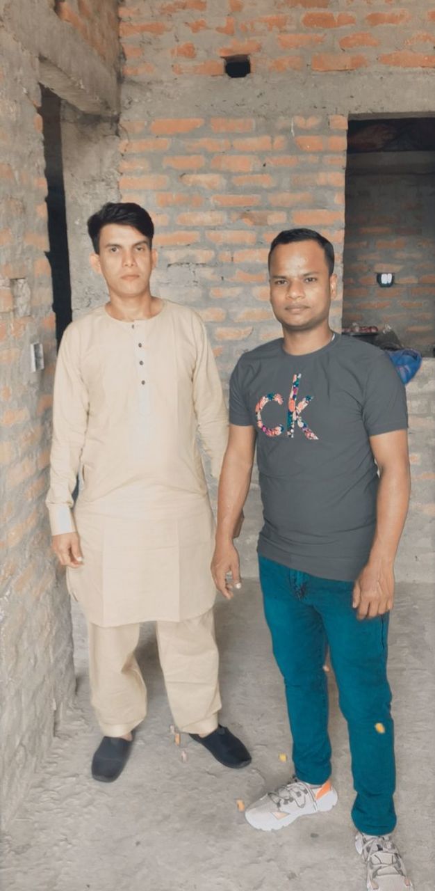 adult, two people, portrait, men, looking at camera, full length, standing, front view, young adult, togetherness, architecture, person, smiling, casual clothing, clothing, wall - building feature, blue, friendship, emotion, lifestyles, footwear, brick, day, happiness