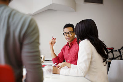 Man looking at businesswoman while sitting in office