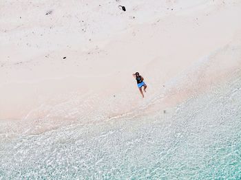 High angle view of man relaxing on shore of beach