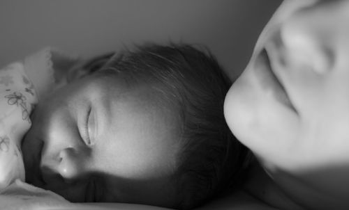 Close-up of baby sleeping on bed at home