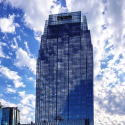 Low angle view of modern building against cloudy sky