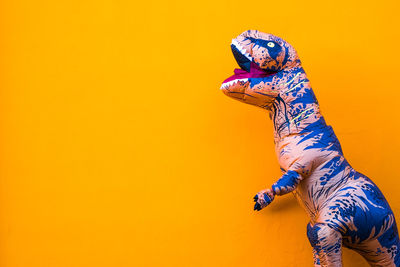 Low section of person with arms raised against orange background