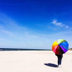 Rear view of man standing on umbrella
