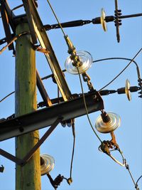 Low angle view of lighting equipment against clear blue sky