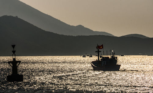 Fishing boat in sea against sky