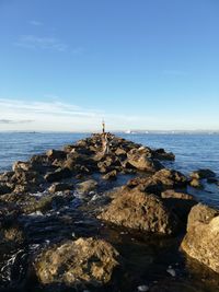 Rock formation on beach against sky