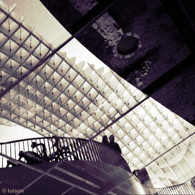 indoors, high angle view, architecture, built structure, shadow, wall - building feature, window, sunlight, tiled floor, glass - material, metal, no people, railing, pattern, day, reflection, flooring, steps, modern, tile