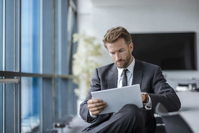 Businessman sitting in conference room using tablet