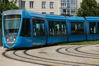 View of railroad tracks by street in city