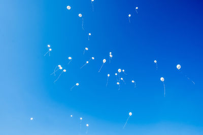 Low angle view of balloons against blue sky