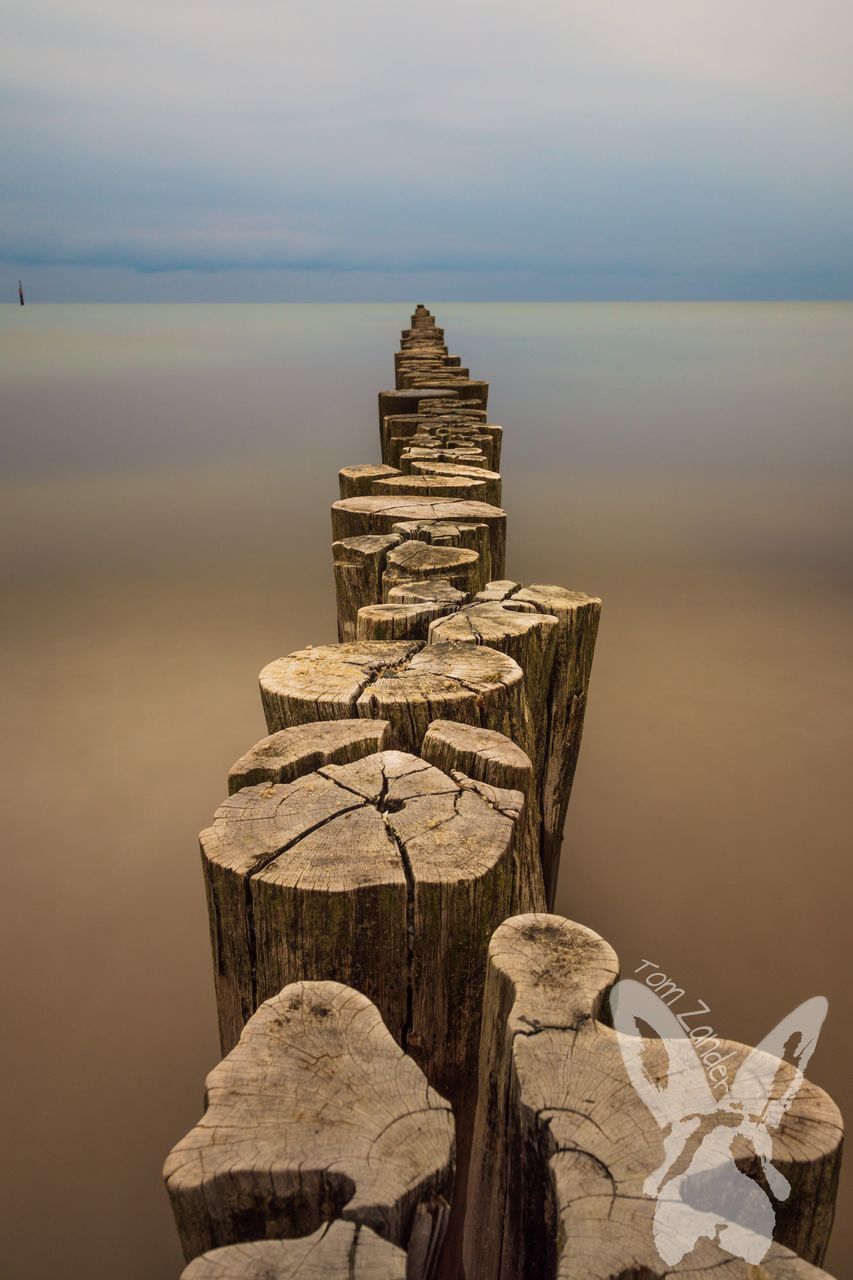 water, sky, no people, nature, sea, scenics - nature, tranquility, tranquil scene, beauty in nature, focus on foreground, built structure, architecture, solid, land, horizon over water, wood - material, history, horizon, ancient civilization, wooden post