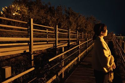 Rear view of woman standing at night