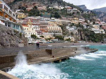 Scenic view of sea by buildings in city