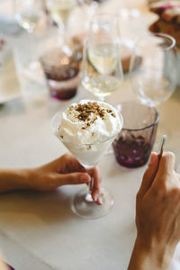 Midsection of woman holding ice cream on table