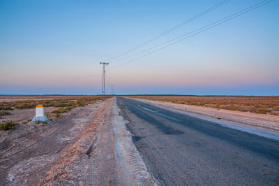 Road amidst field against sky