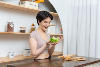 Portrait of young woman sitting on table