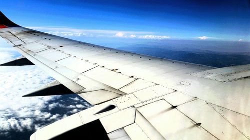 Low angle view of airplane flying against blue sky