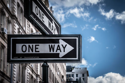 Low angle view of road sign against sky