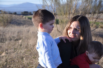 Portrait of smiling friends standing on field