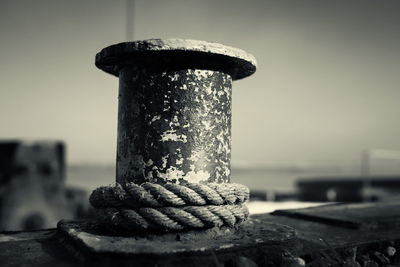 Close-up of rope on weathered boat bollard