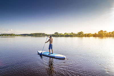 Woman in boat on lake against sky