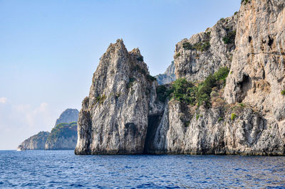 Panoramic view of rock formation by sea against sky