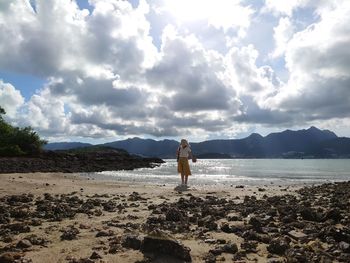 Man standing on beach against sky