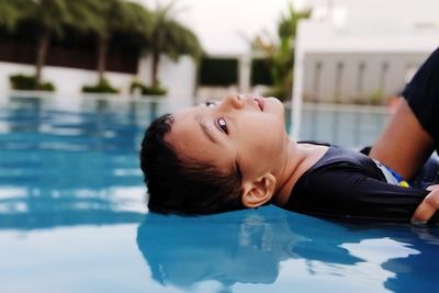 Portrait of boy floating on swimming pool