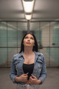 Fashionable young woman standing in illuminated built structure